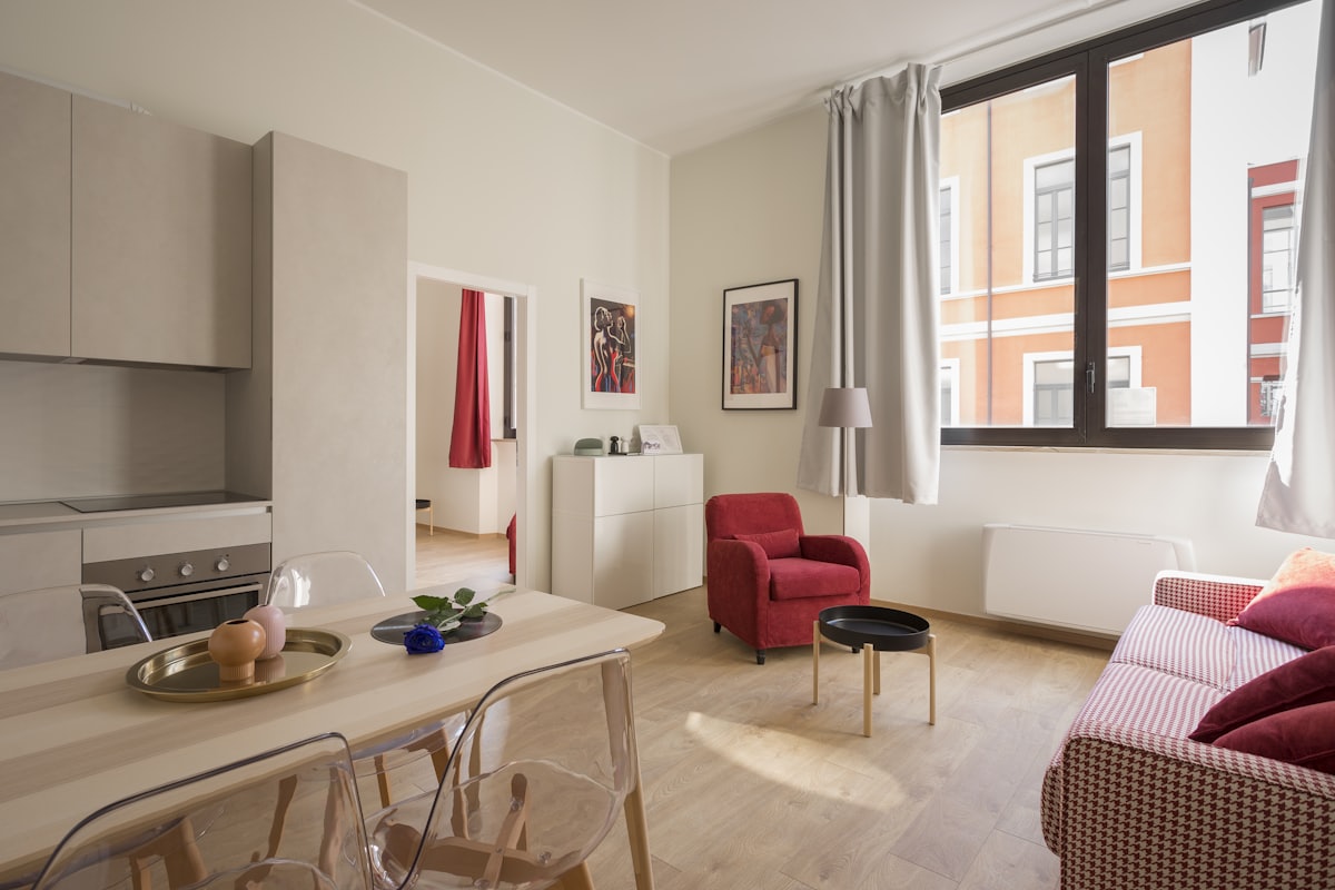 Small sunny flat lounge with sofa, desk and plants — flat moving tips blog cover