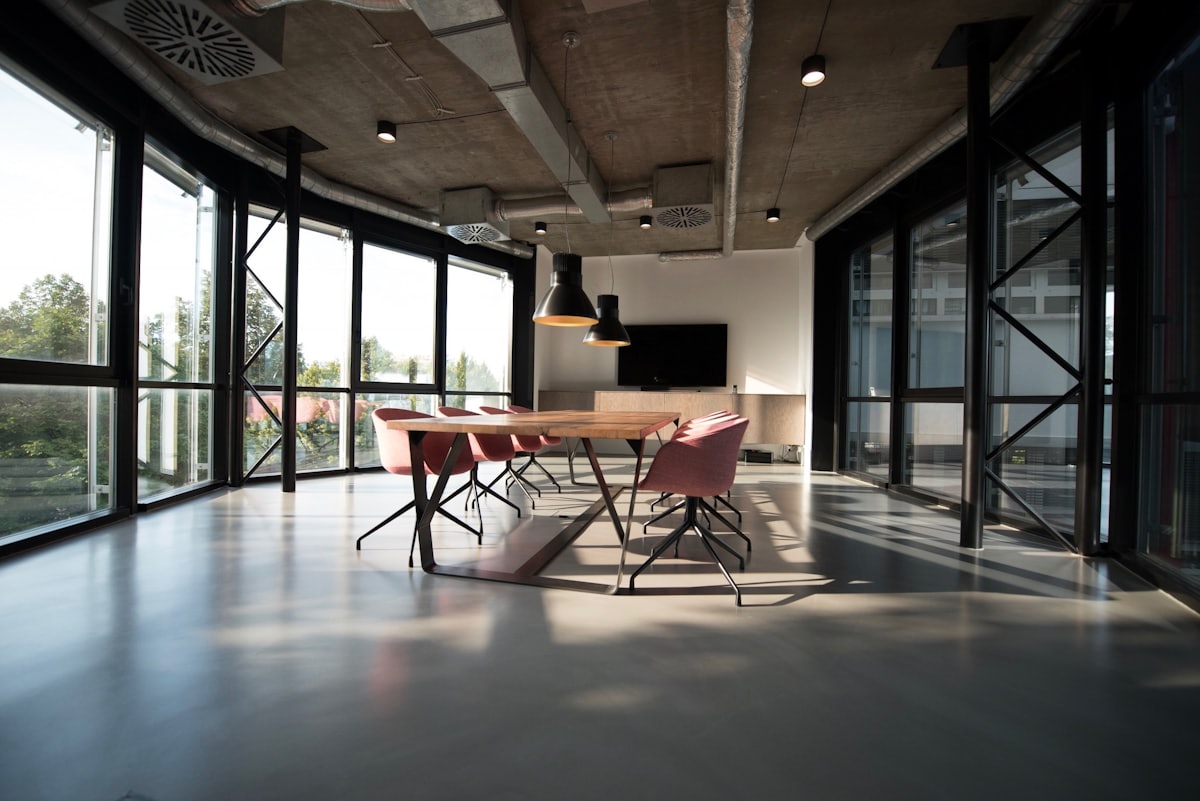 Sunlit office meeting room with large table and red chairs — office move checklist blog cover
