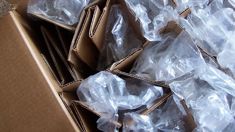 Open moving box with cardboard dividers and air-pillow cushioning protecting fragile items