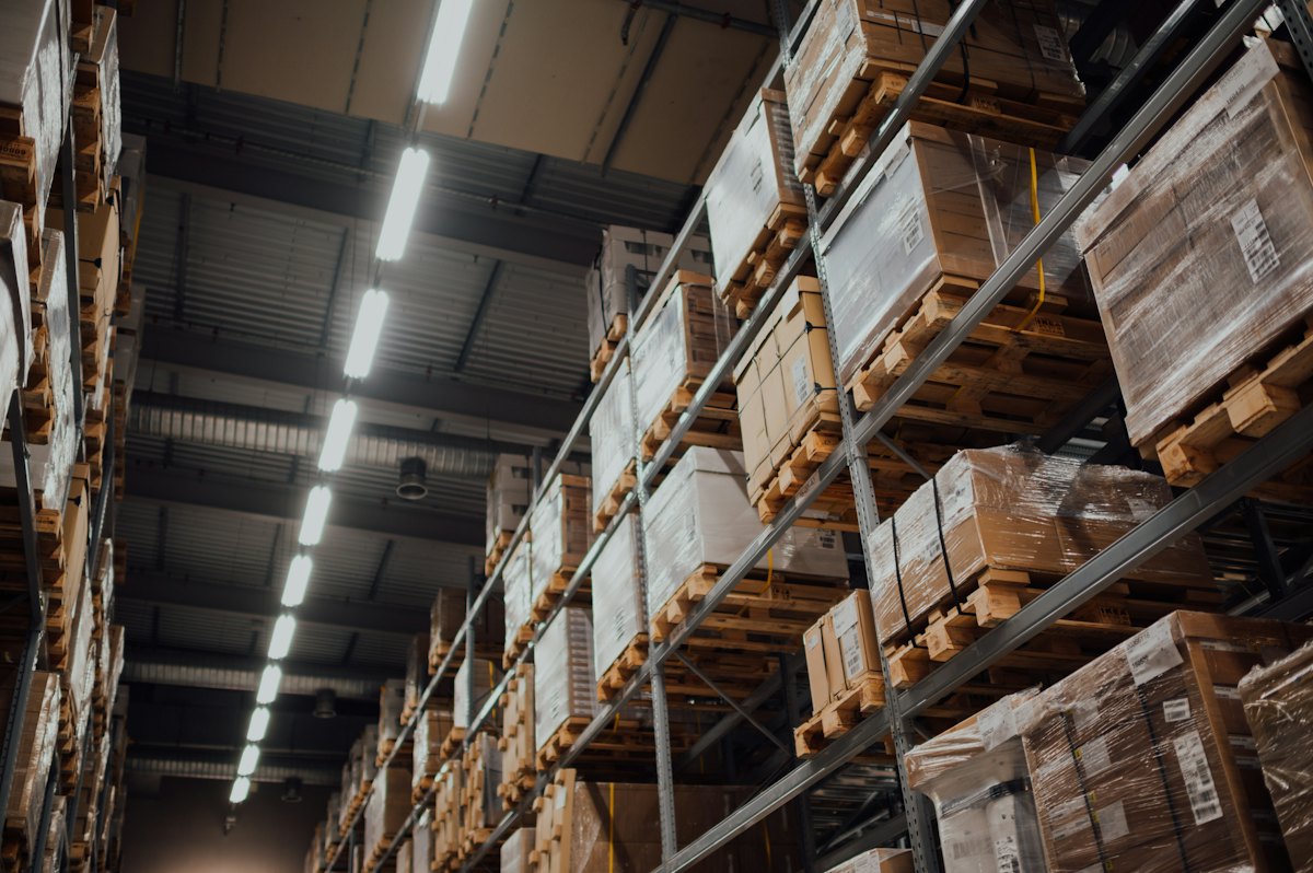 Pallet racking aisle stacked with wrapped cartons — short-term storage between moves blog cover