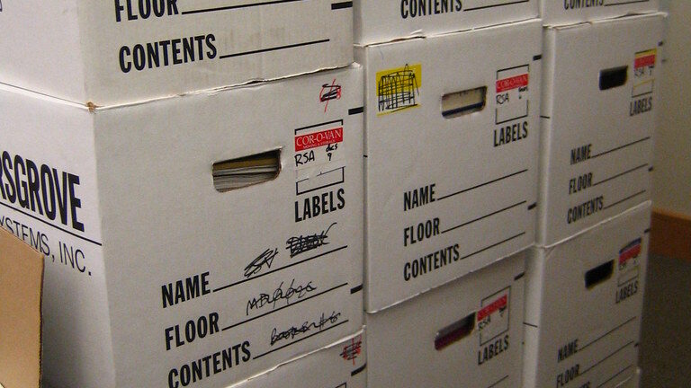 Tall stacks of labelled white office archive boxes ready for an office relocation