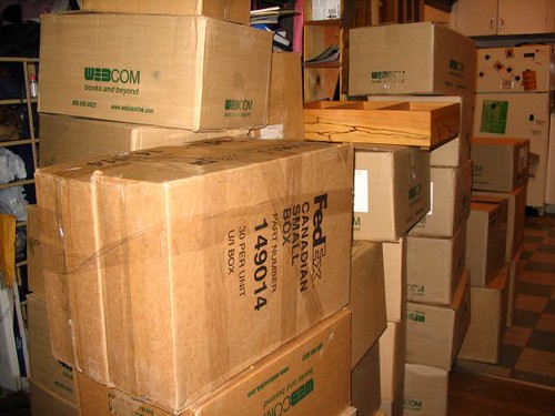 Room filled with stacked sealed cardboard moving boxes ready for transport on moving day