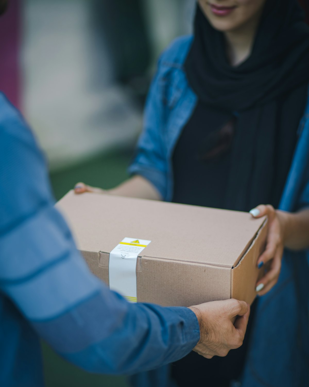 Mover handing a sealed cardboard packing box to a customer — packing, unpacking and moving boxes